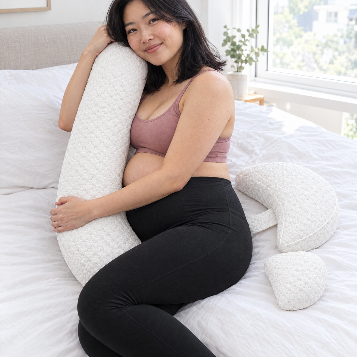 Mum-to-be hugging the Bump Nest Plus long pillow